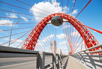 Red metal arch over the highway. Zhivopisny bridge. Moscow.