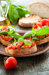 Italian bruschetta with chopped vegetables, herbs and oil on gr