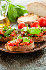 Italian bruschetta with chopped vegetables, herbs and oil on gr