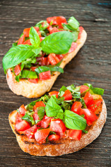 Italian bruschetta with chopped vegetables, herbs and oil on gr