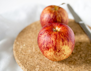 Two red apples on cork mat