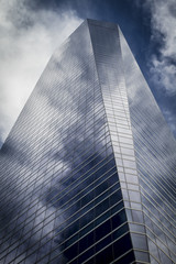 Fototapeta na wymiar enterprise, skyscraper with glass facade and clouds reflected in