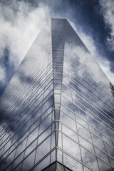 Obraz premium enterprise, skyscraper with glass facade and clouds reflected in