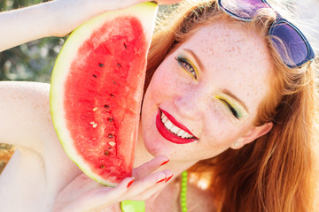 Smiling girl with freckles holding melon