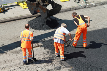 Straßenbauarbeiter mit Schaufeln