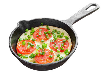 frying pan with scrambled eggs and tomatoes