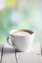 Coffee cup on a wooden table outdoors