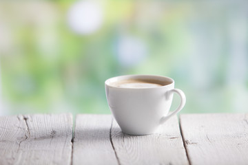 Coffee cup on a wooden table outdoors
