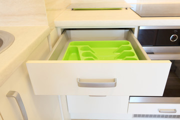 Empty green plastic cutlery tray in kitchen drawer