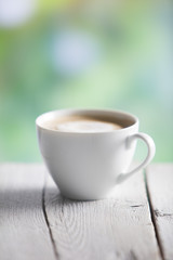 Coffee cup on a wooden table outdoors