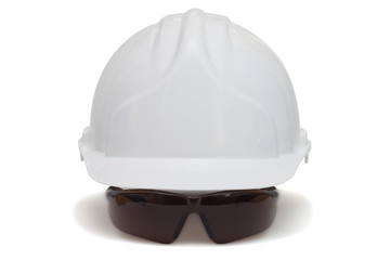 Construction helmet and safety goggles on white background