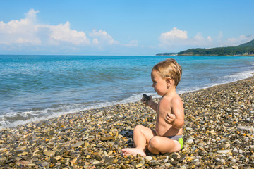 Fototapeta na wymiar Baby boy in lotus pose on beach