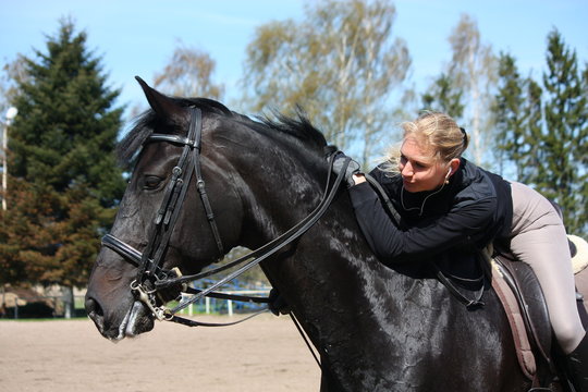 Blonde woman and black horse