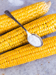 boiled yellow corn and a teaspoon of salt, close up