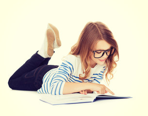 smiling little student girl lying on the floor