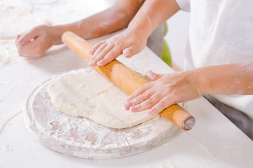 Obraz na płótnie Canvas Children rolling out dough