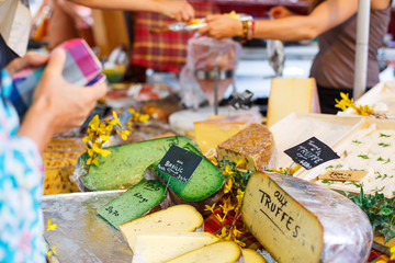 Selling and buying cheese  on market place in Provence, France.