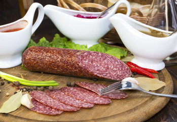 sausages on a wooden plate with vegetables in a restaurant