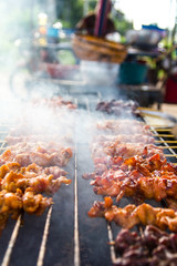 Close-up of chicken pieces grilled on skewers with smoke steel