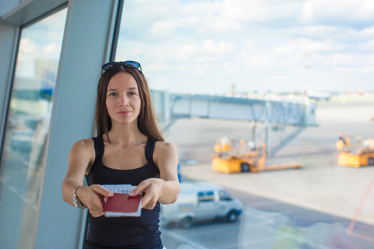 Woman holding passports and boarding pass at airport waiting the