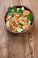 Shrimps, cucumber and lime salad over wooden background