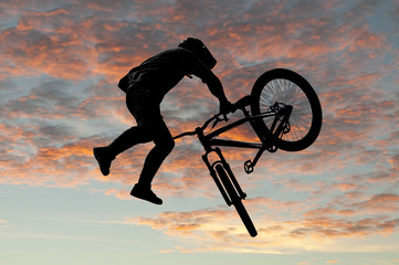 Silhouette bmx sport rider in action with scenery background