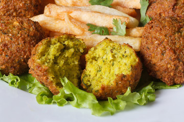 falafel with French fries, lettuce on a white plate macro