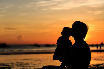 Father and little daughter on beach at sunset