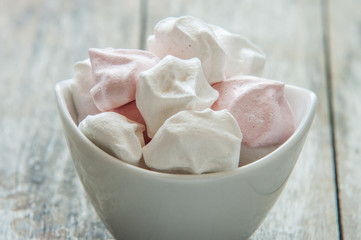 Meringue cookies in bowl close up