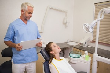 Fototapeta premium Dentist standing over patient in the chair