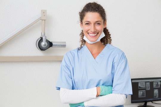 Dentist In Blue Scrubs Smiling At Camera