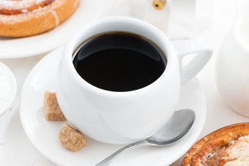 cup of black coffee and sweet bun for breakfast, close-up