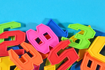 Heap of plastic colored numbers on a blue background