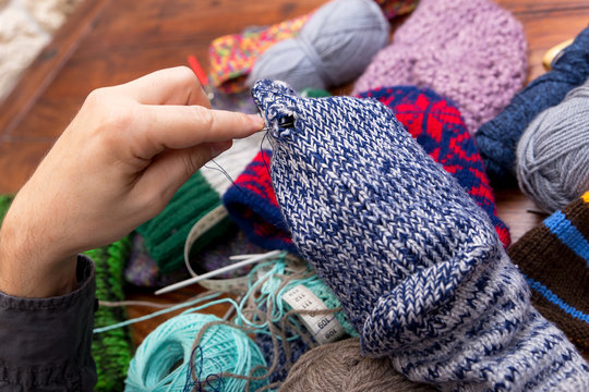 Nahaufnahme von einem Mann der L&ouml;cher in einem Socken stopft