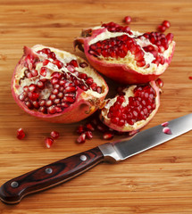 Delicious pomegranate with seeds on wooden table