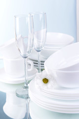 Set of white dishes on table on light background