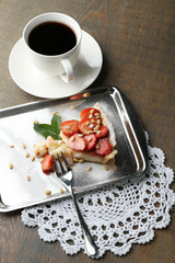 Piece of strawberry tart on  tray, on rustic wooden background