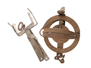 two old and rusty vermin traps on a white background.