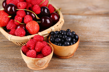 Berries in basket on wooden background