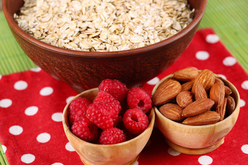 Big round bowl with oatmeal, nuts and raspberries