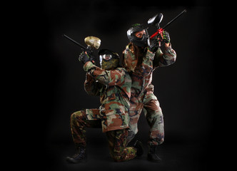 Studio shot of two paintball players on black background