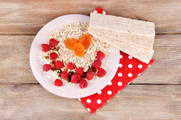 Big plate with oatmeal, small loaves of bread and berries