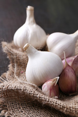 Garlic on sackcloth, on black wooden background