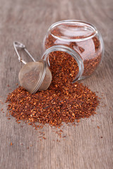 Dried rooibos tea in glass jar on wooden table
