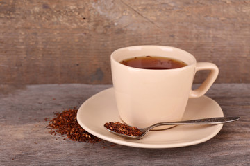 Cup of tasty rooibos tea, on wooden table