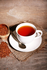 Cup of tasty rooibos tea, on wooden table