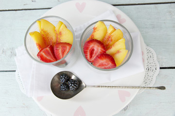 fresh tasty fruit salad on blue wooden table