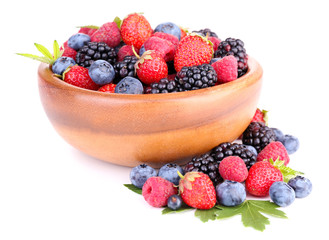 Ripe sweet different berries in wooden bowl, isolated on white