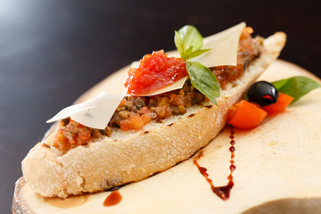 Italian appetizer bruschetta with tomato, basil and black olives