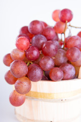 Red grapes in a rustic wooden bucket